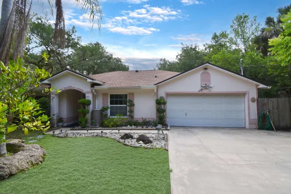 a front view of a house with a garden and yard