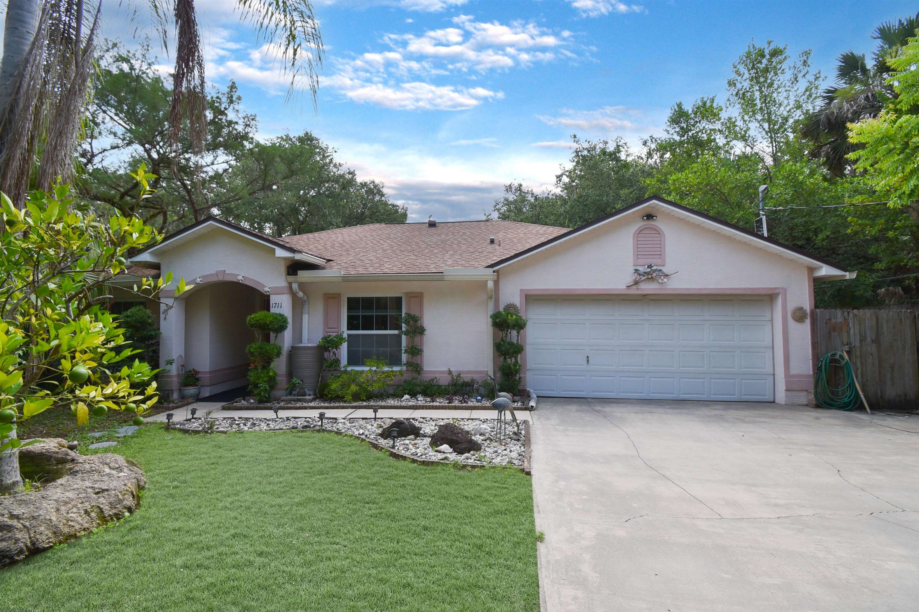 a front view of a house with a garden and yard