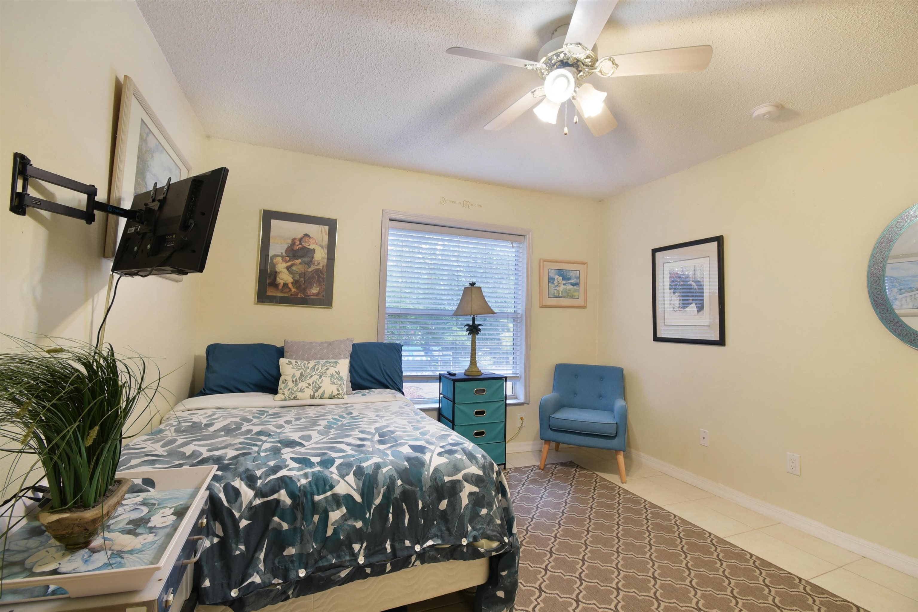 1711 Old Beach Road St. Augustine, FL 32080 - Photo 20 of 34 a bedroom with a bed a lamp and a flat screen tv