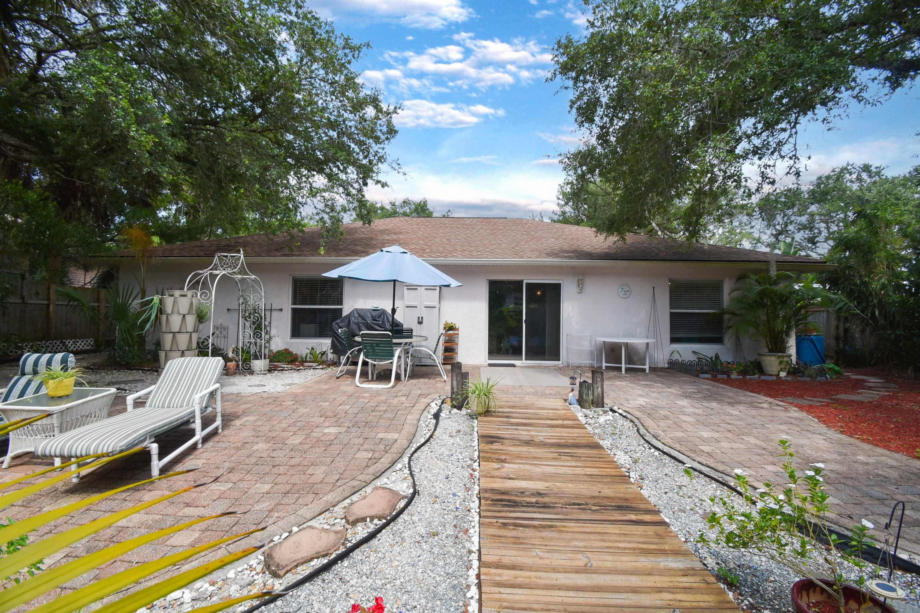 1711 Old Beach Road St. Augustine, FL 32080 - Photo 23 of 34 a view of a patio with table and chairs under an umbrella