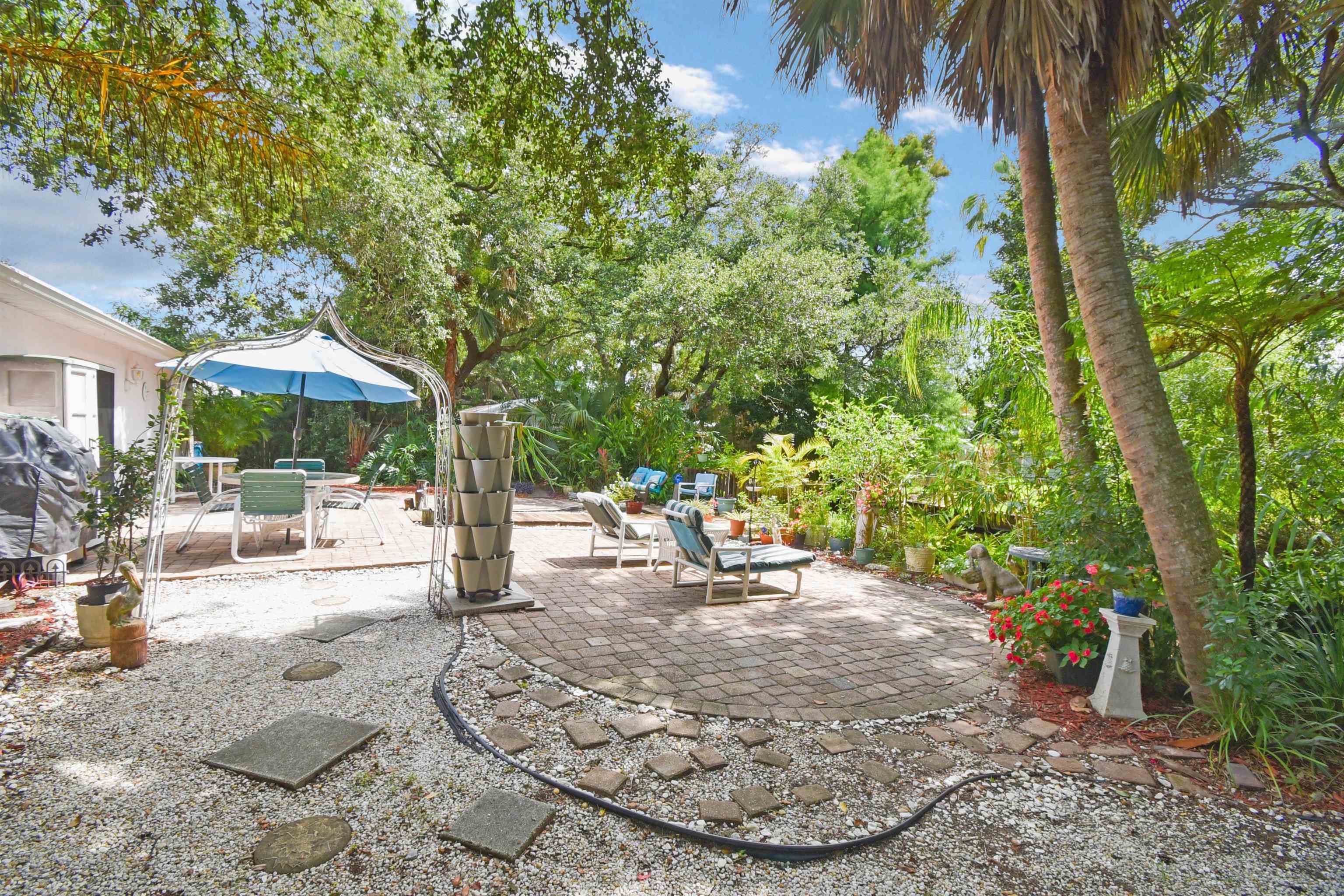 1711 Old Beach Road St. Augustine, FL 32080 - Photo 26 of 34 a view of a patio with table and chairs under an umbrella