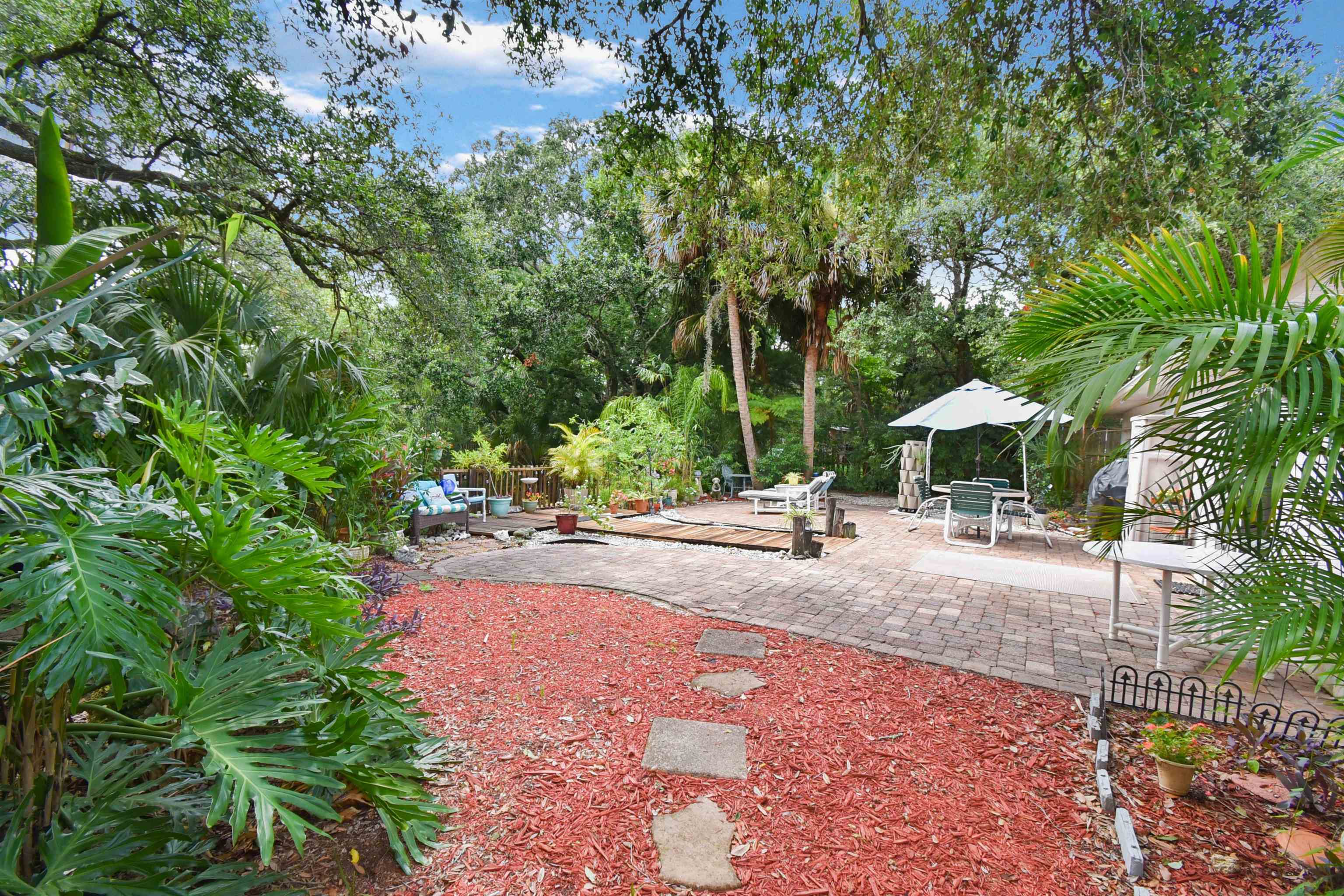 1711 Old Beach Road St. Augustine, FL 32080 - Photo 27 of 34 a backyard of a house with table and chairs under an umbrella