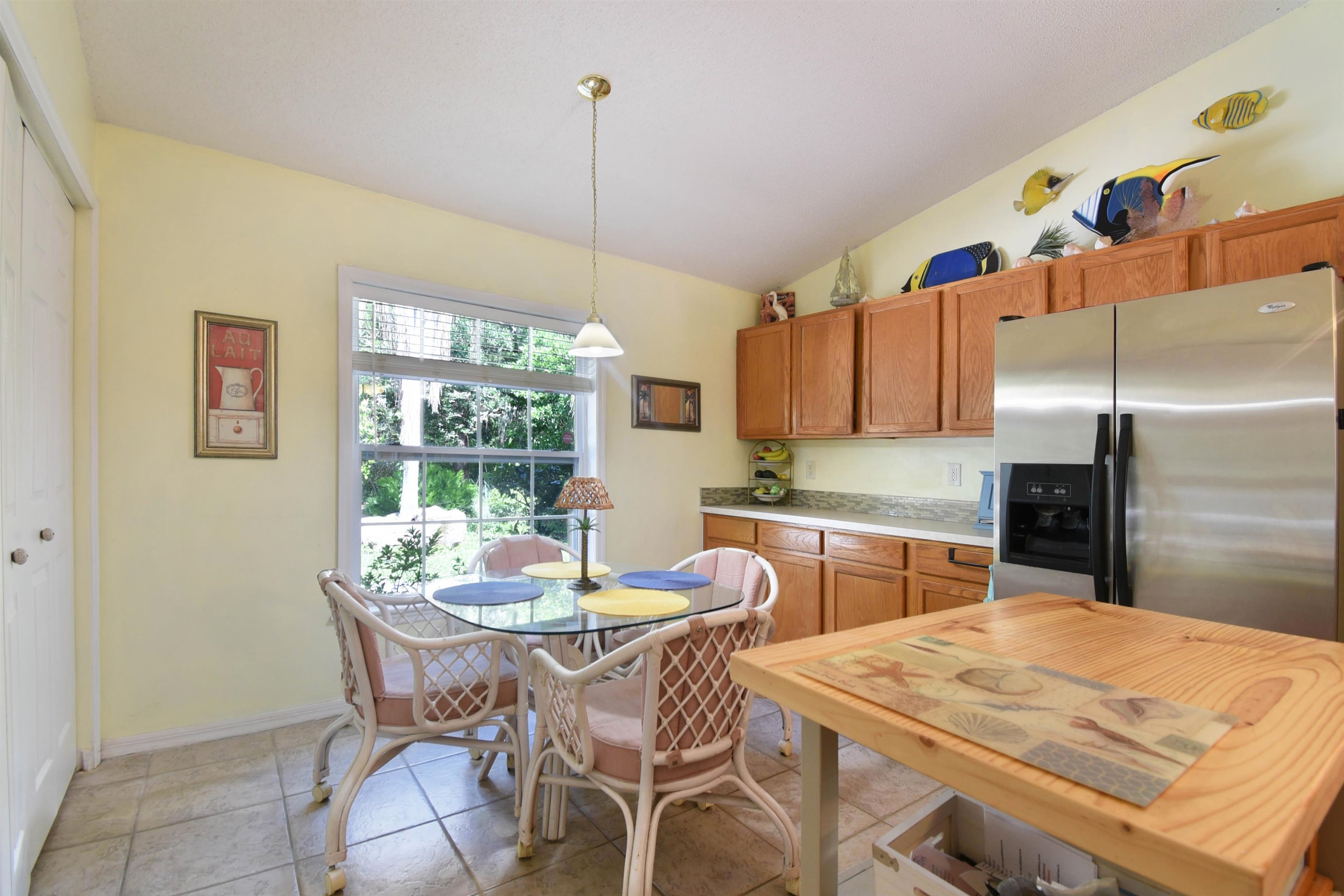 1711 Old Beach Road St. Augustine, FL 32080 - Photo 5 of 34 a kitchen with stainless steel appliances kitchen island granite countertop a dining table chairs and a refrigerator