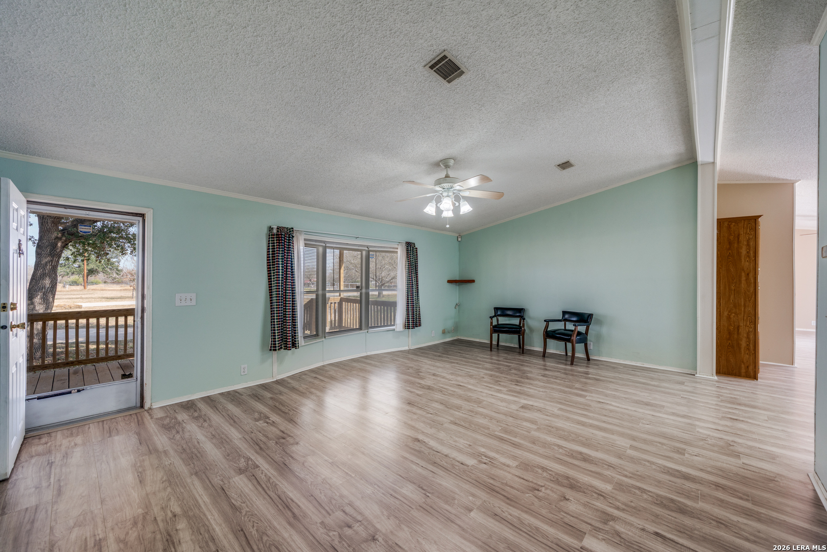 14975 Flatten Road San Antonio, TX 78223 - Photo 6 of 28 a view of an empty room with window and wooden floor