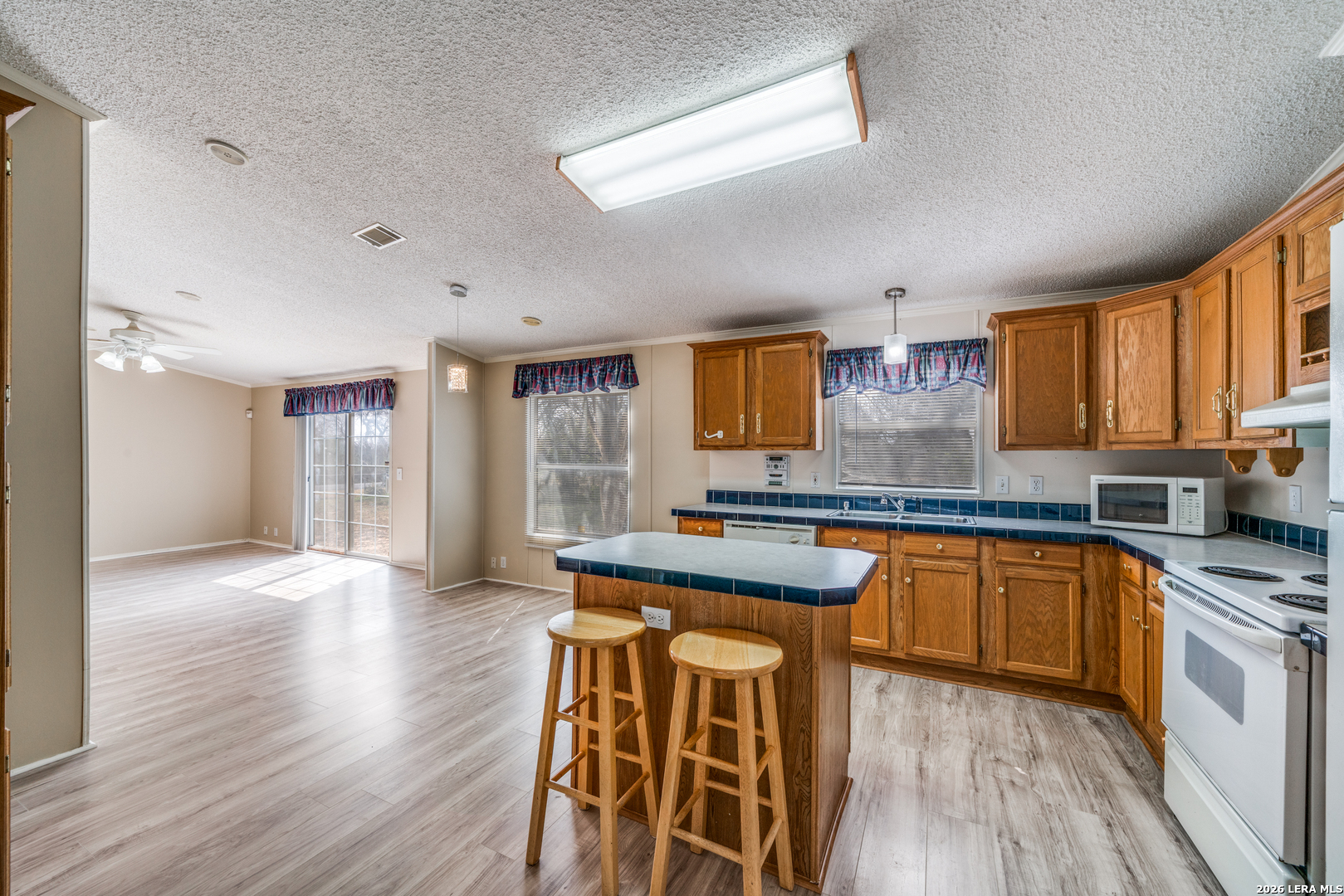 14975 Flatten Road San Antonio, TX 78223 - Photo 8 of 28 a kitchen with stainless steel appliances granite countertop wooden floors and view living room