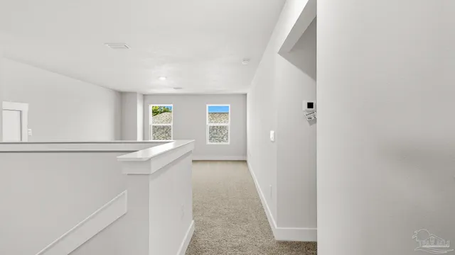 a view of hallway with window and wooden floor