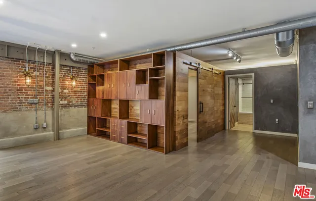 a view of empty room with wooden floor and cabinet