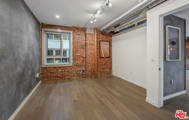 en empty room with wooden floor and windows