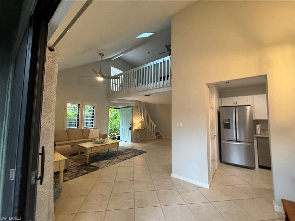 1281 Solana Road Naples, FL 34103 - Photo 11 of 31 Living room featuring stairs, light tile patterned floors, a ceiling fan, and baseboards