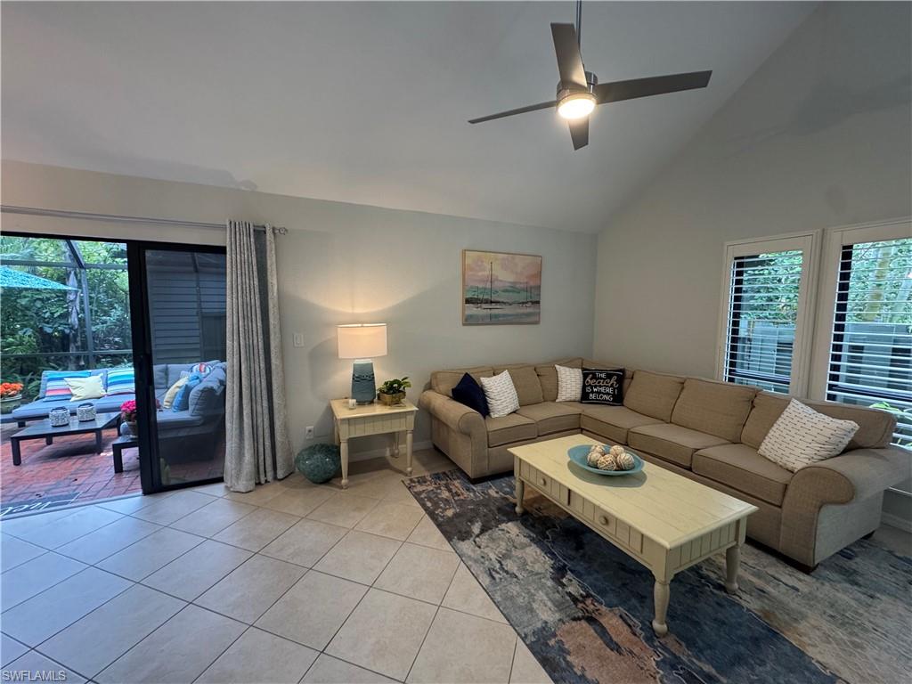 1281 Solana Road Naples, FL 34103 - Photo 4 of 31 Living room featuring ceiling fan, high vaulted ceiling, and lanai entry