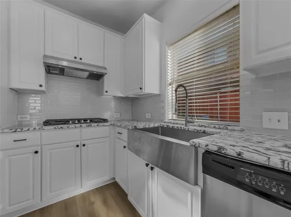 a kitchen with granite countertop a sink stove and cabinets