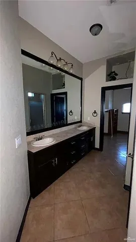 a spacious bathroom with a double vanity sink and a mirror