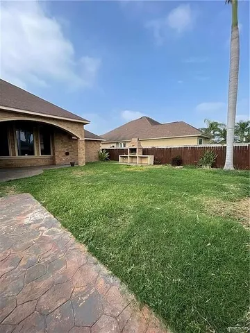 a view of a yard in front of a house with large tree