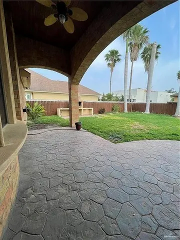 a view of a porch with a table and chairs under an umbrella