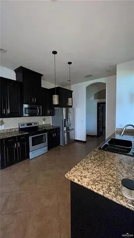 a kitchen with stainless steel appliances granite countertop a stove a sink and a refrigerator