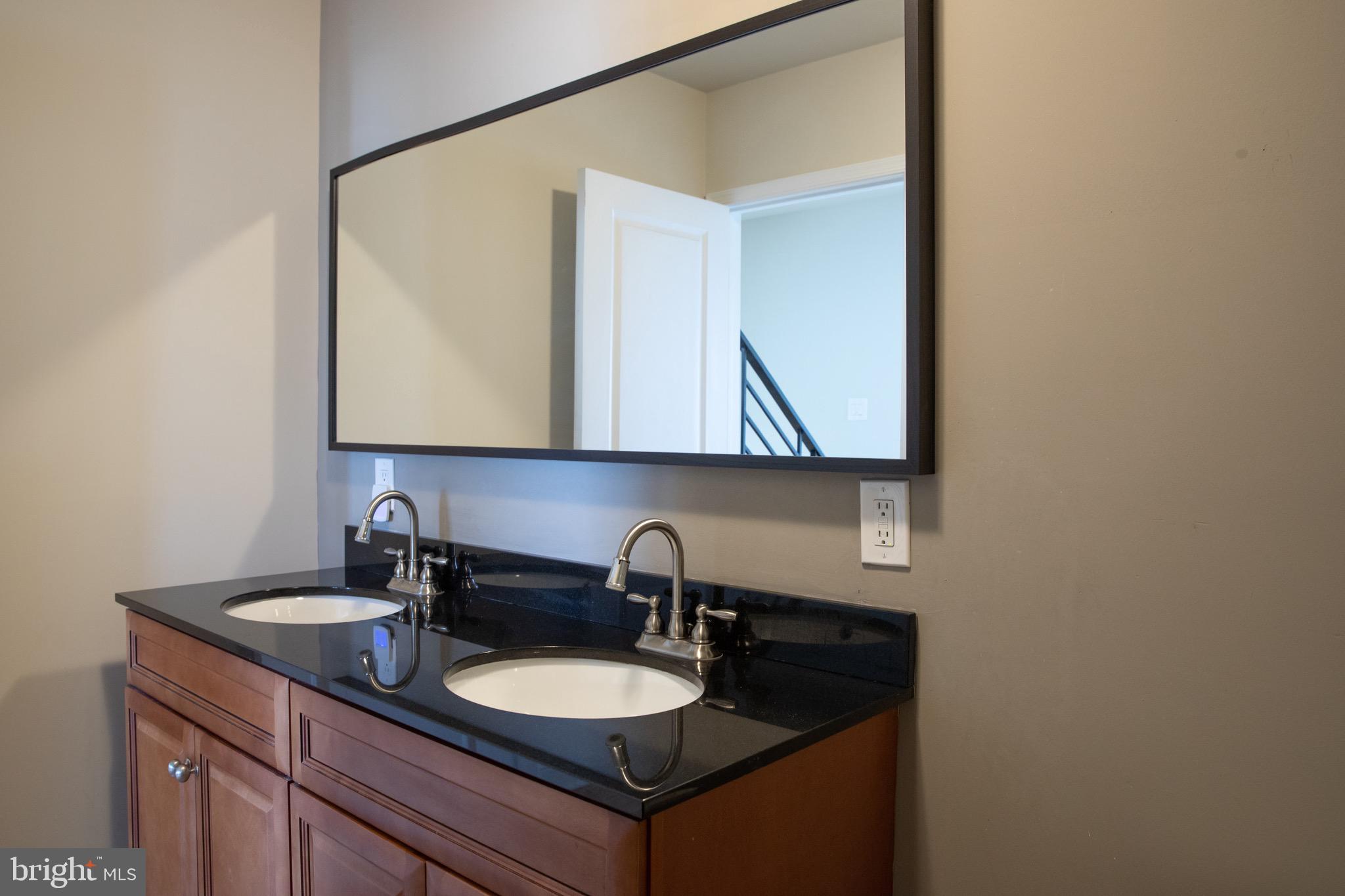 323 East Allen Street, Unit 4 Philadelphia, PA 19125 - Photo 15 of 24 a bathroom with a double vanity sink and a mirror