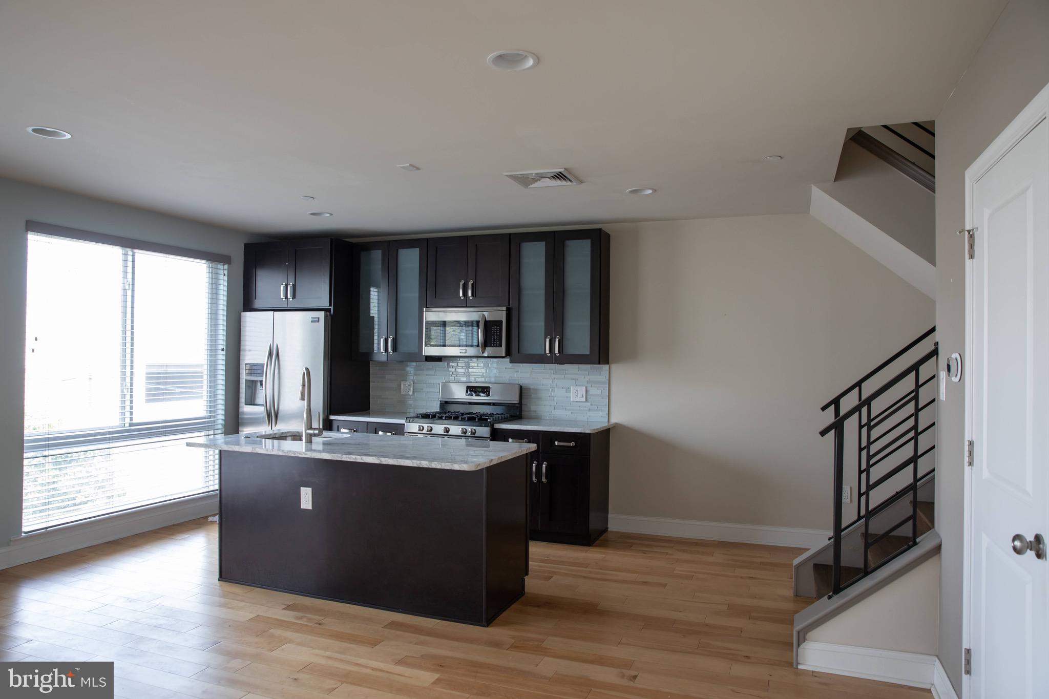 323 East Allen Street, Unit 4 Philadelphia, PA 19125 - Photo 2 of 24 a kitchen with stainless steel appliances granite countertop a sink stove and refrigerator