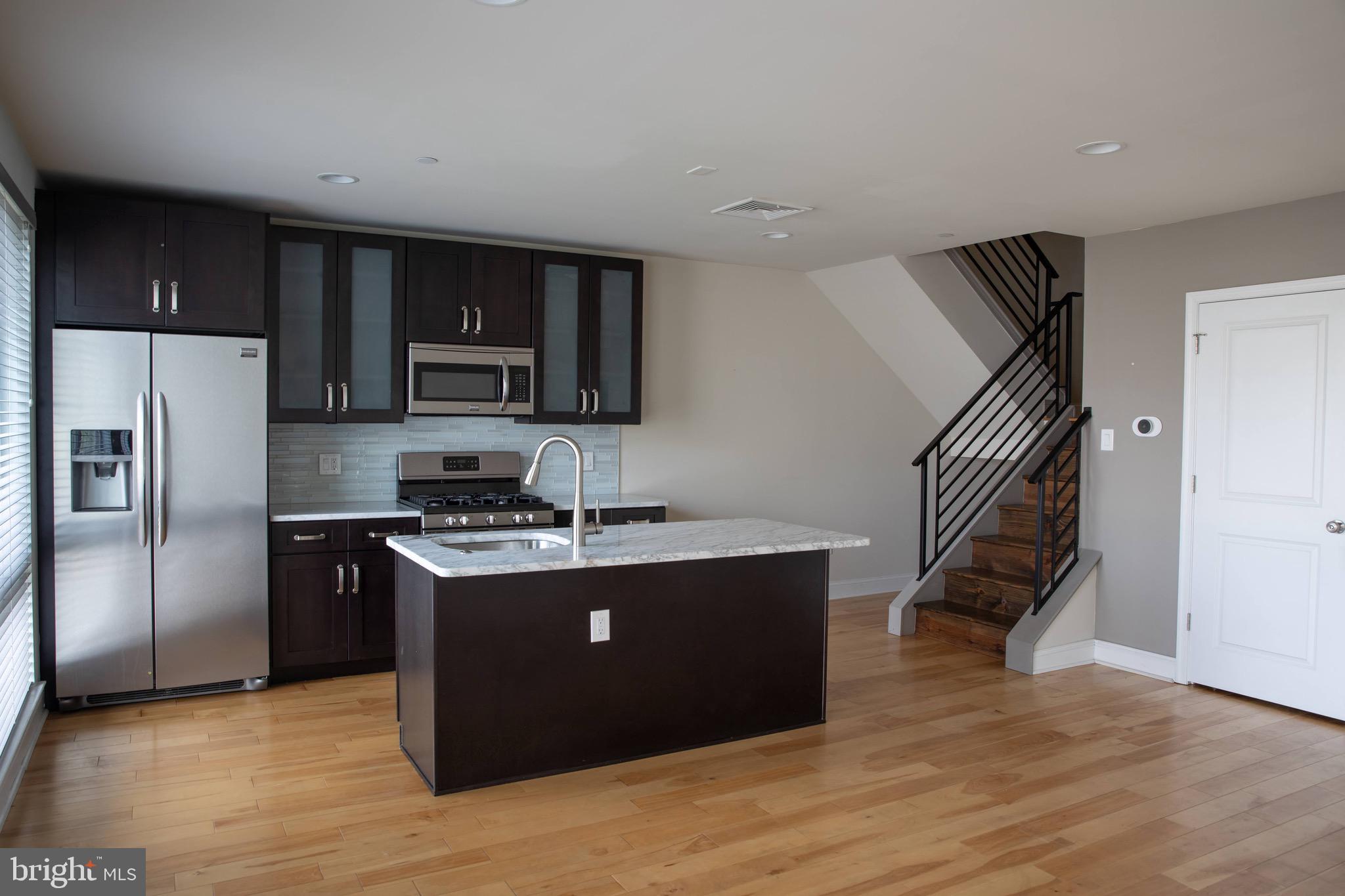 323 East Allen Street, Unit 4 Philadelphia, PA 19125 - Photo 3 of 24 a kitchen with kitchen island a counter top space cabinets and stainless steel appliances