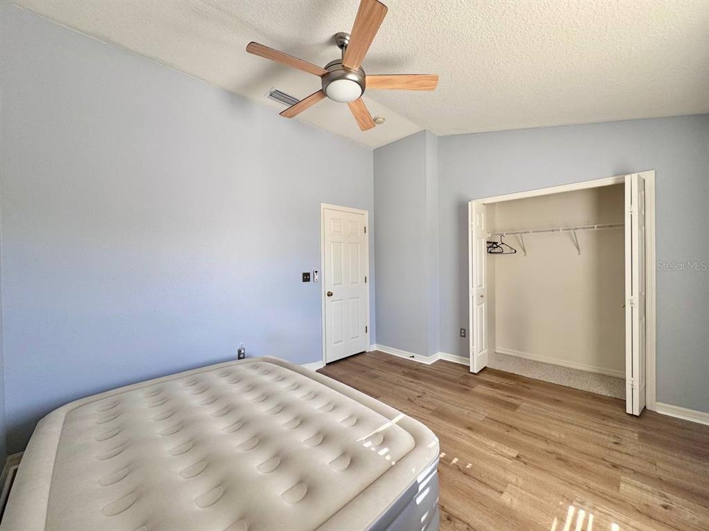 10035 Tranquility Way Tampa, FL 33625 - Photo 16 of 28 a bedroom with a bed and a chandelier