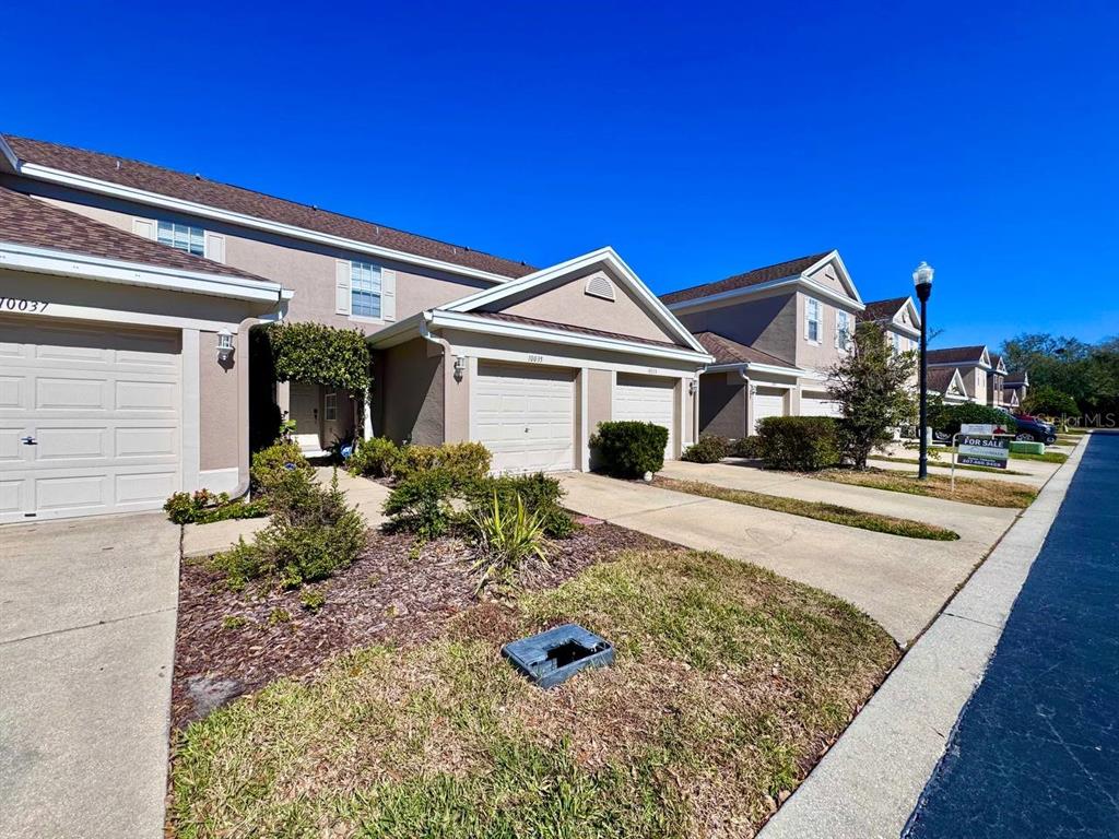 10035 Tranquility Way Tampa, FL 33625 - Photo 2 of 28 a front view of a house with garden