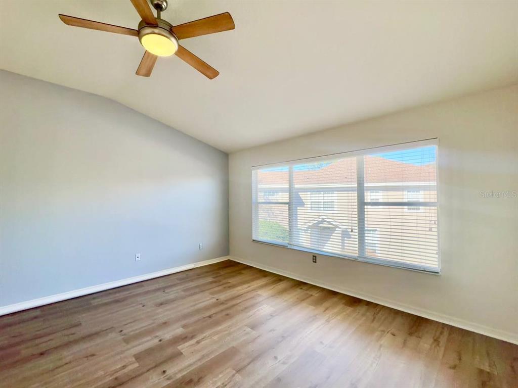 10035 Tranquility Way Tampa, FL 33625 - Photo 21 of 28 an empty room with wooden floor fan and windows