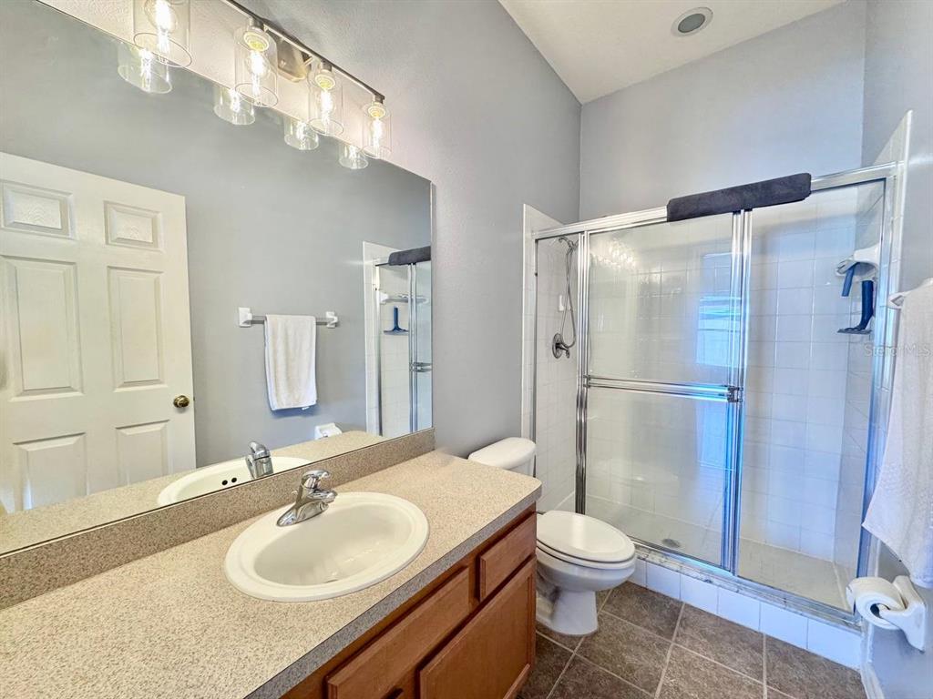 10035 Tranquility Way Tampa, FL 33625 - Photo 22 of 28 a bathroom with a granite countertop sink toilet a mirror and shower