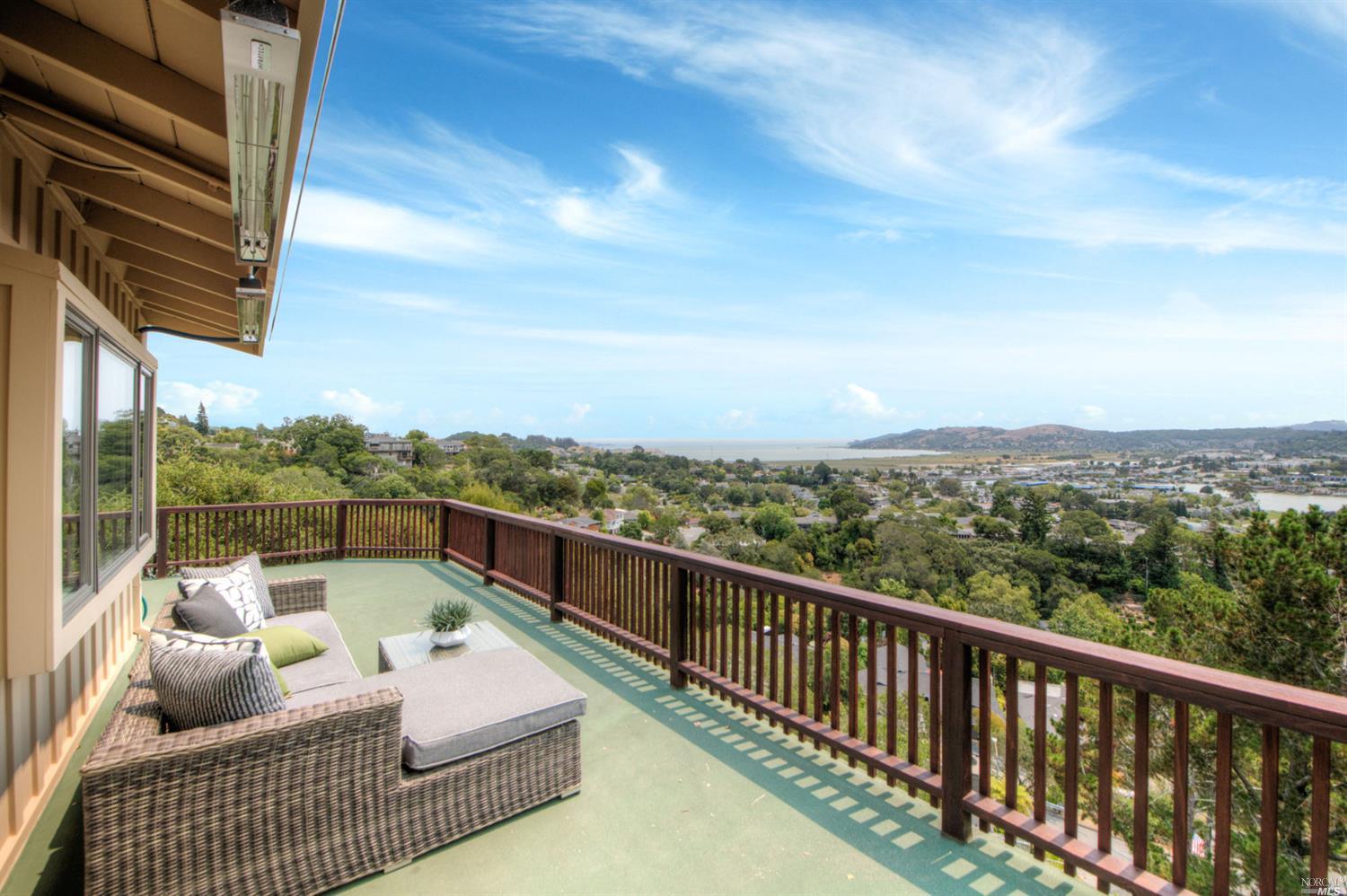 a view of a balcony with couches and wooden floor