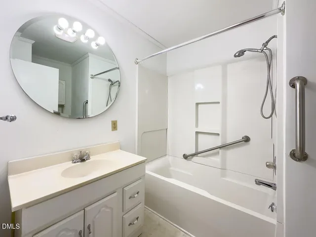 a bathroom with a tub a sink and mirror