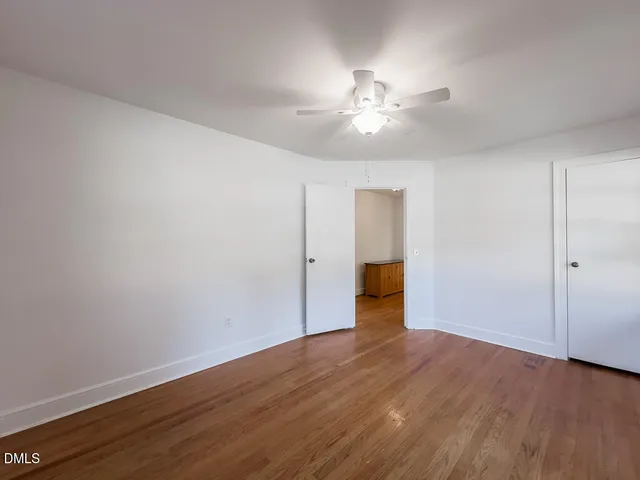 a view of an empty room with wooden floor