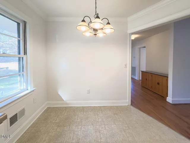 a view of a livingroom with a chandelier fan and windows