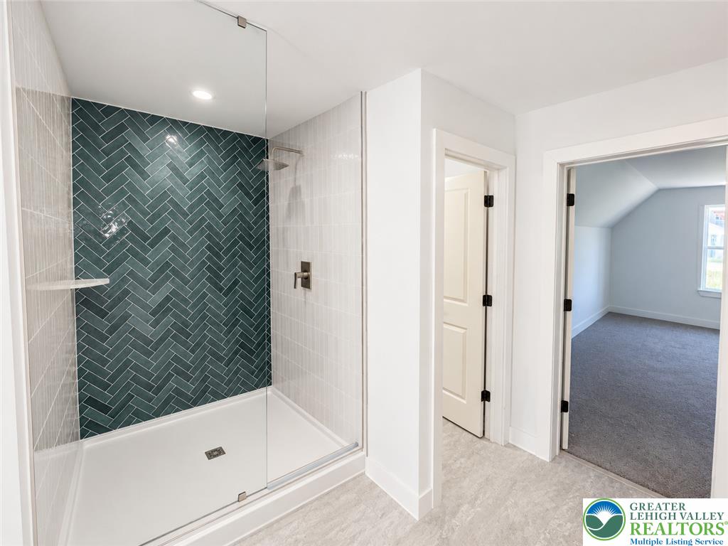 3104 Moyer Road Hellertown, PA 18055 - Photo 7 of 24 Geometric herringbone tilework defines the modern walk-in shower in this sleek secondary bathroom.