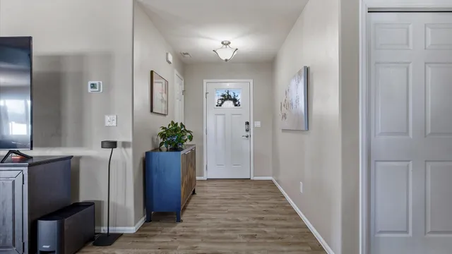 a view of a hallway with wooden floor and a bathroom