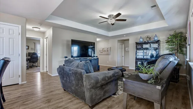 a living room with furniture and a wooden floor