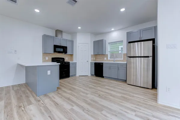 a kitchen with a refrigerator and a stove top oven