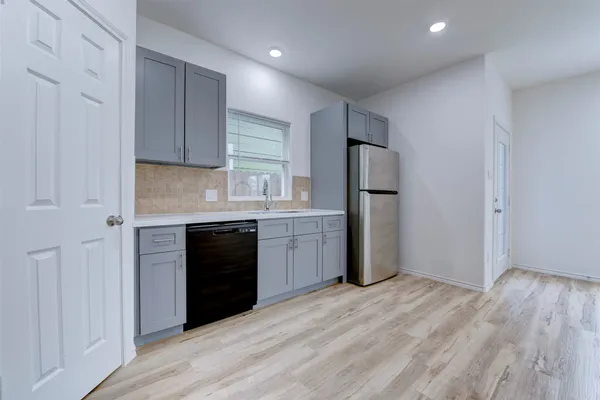 a kitchen with a refrigerator and a stove top oven