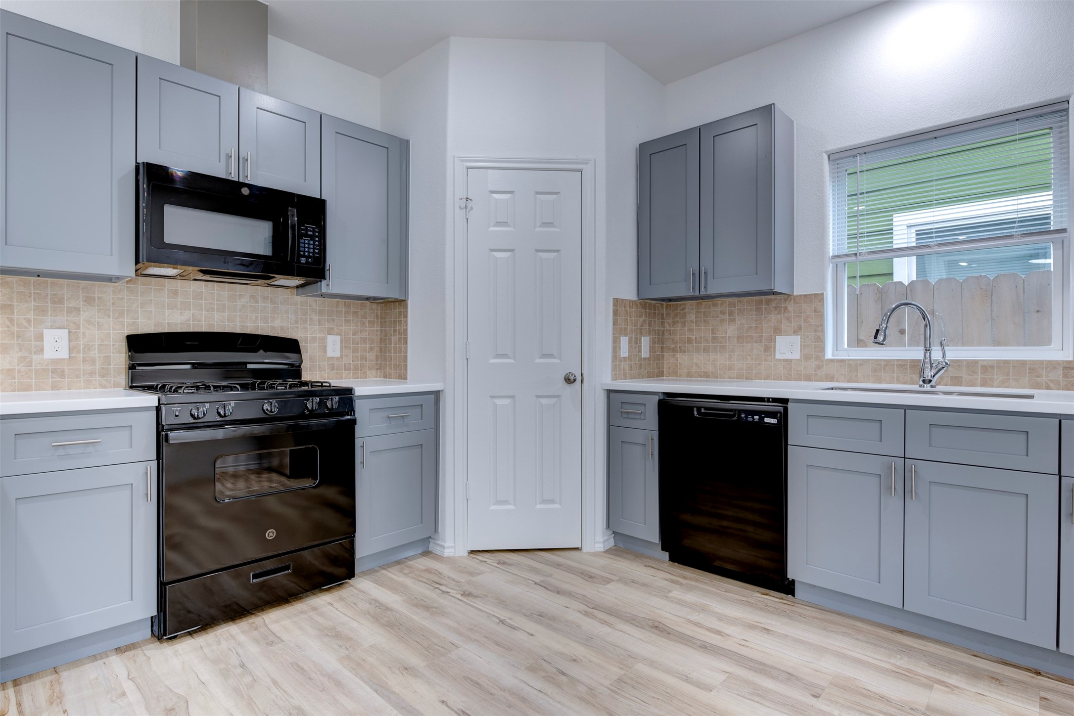 8203 Woodlyn Road, Unit F Houston, TX 77028 - Photo 17 of 29 a kitchen with stainless steel appliances granite countertop a stove a sink and a microwave