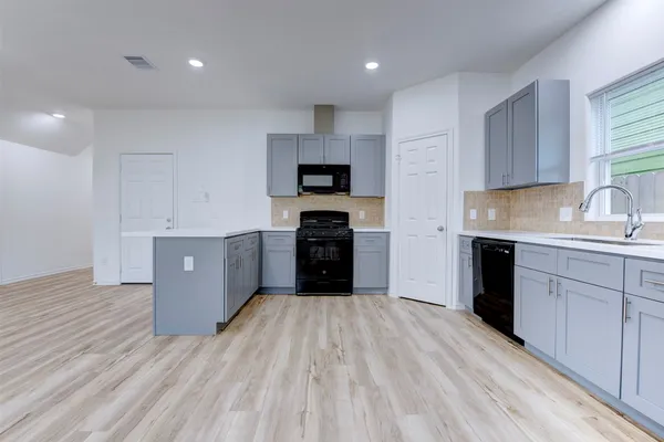 a kitchen with a sink a stove and cabinets