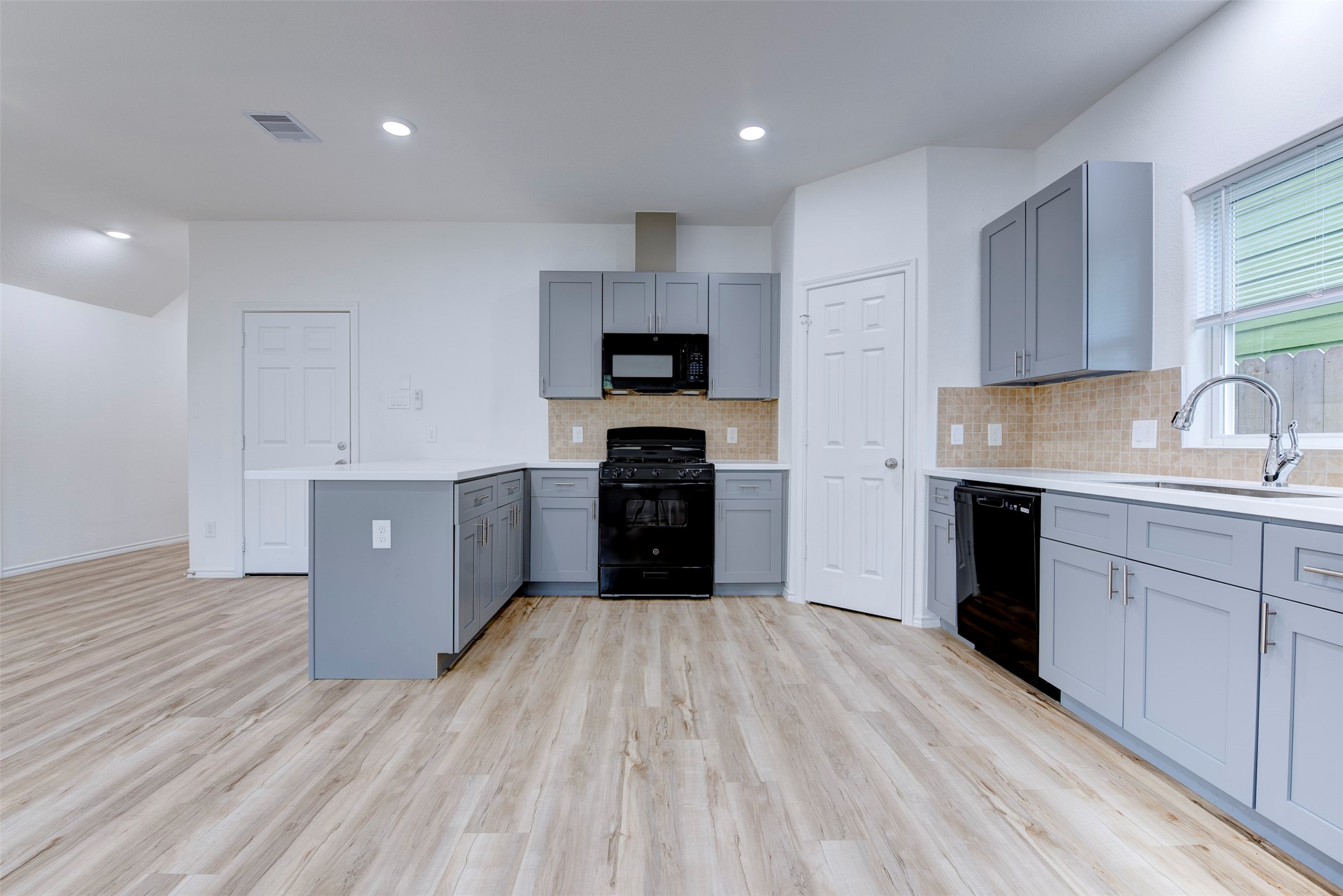 8203 Woodlyn Road, Unit F Houston, TX 77028 - Photo 18 of 29 a kitchen with a sink a stove and cabinets