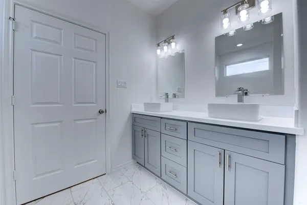 a spacious bathroom with double sink and mirror
