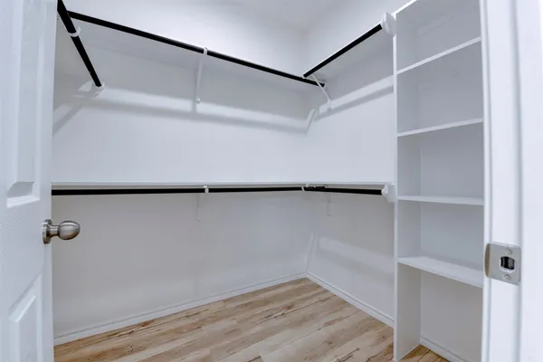 a view of walk in closet with empty racks