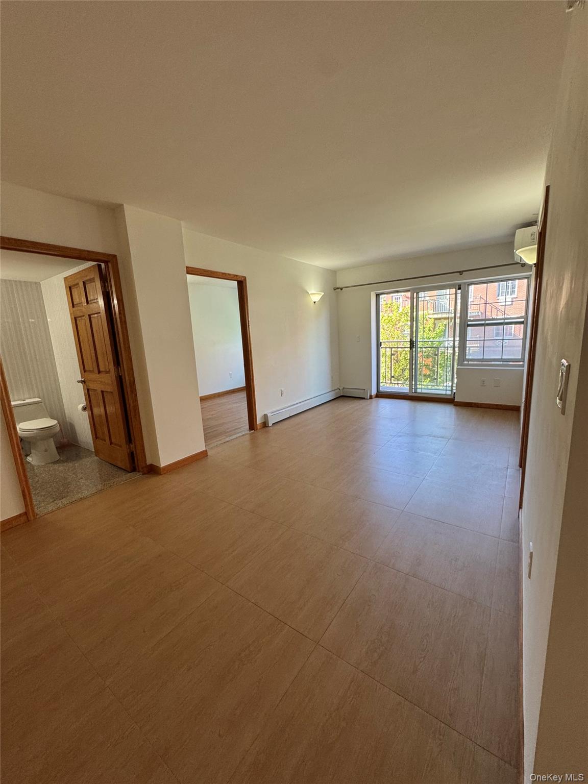 35-19 Leavitt Street, Unit 3E Queens, NY 11354 - Photo 6 of 8 Unfurnished room featuring a baseboard radiator and a wall mounted air conditioner
