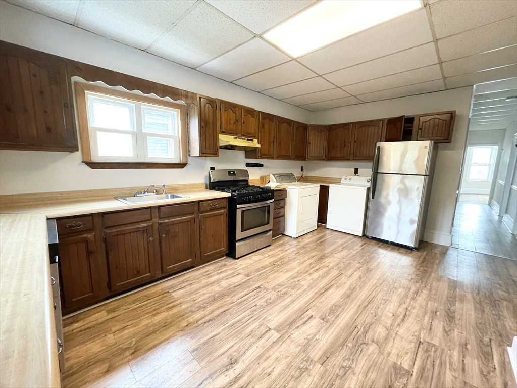 26-28 Harbor View Street, Unit 3 Boston, MA 02125 - Photo 2 of 9 a kitchen with a sink a window and stainless steel appliances