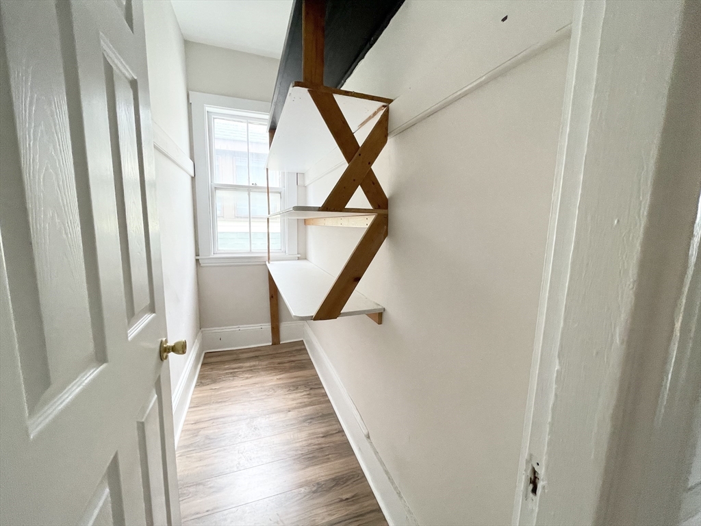 26-28 Harbor View Street, Unit 3 Boston, MA 02125 - Photo 5 of 9 a view of a hallway with wooden floor and stairs