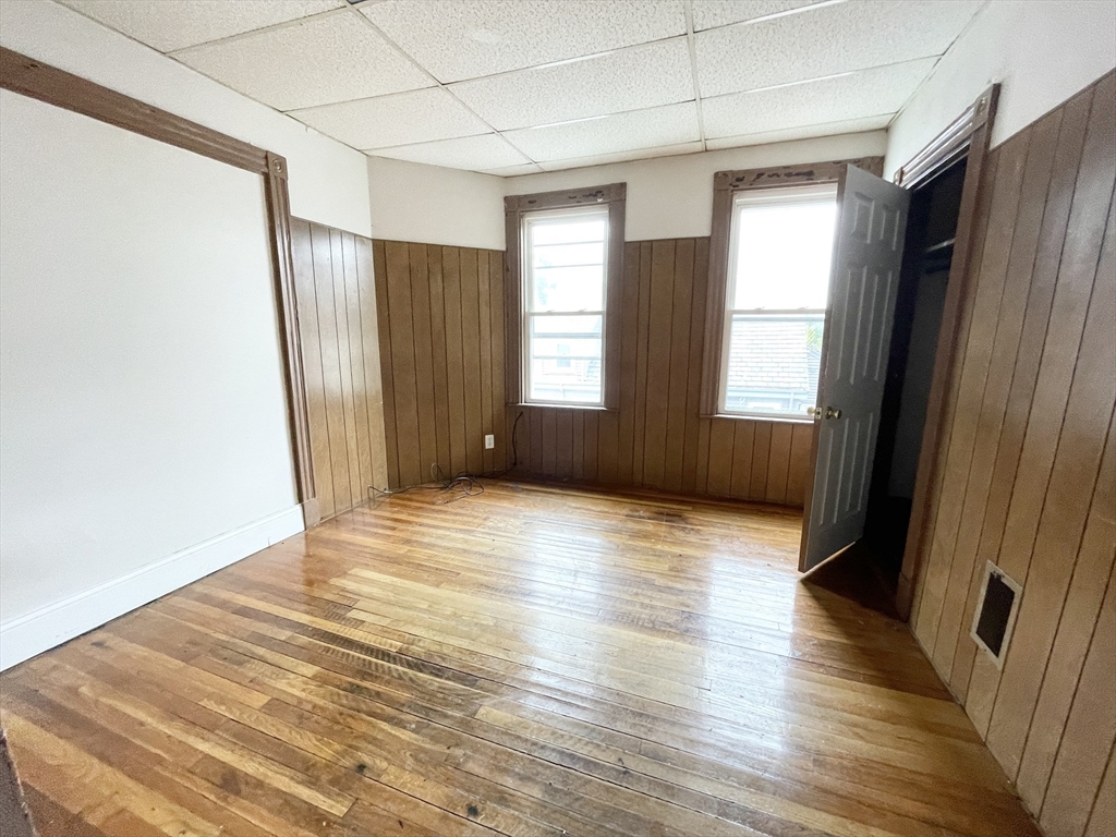 26-28 Harbor View Street, Unit 3 Boston, MA 02125 - Photo 6 of 9 an empty room with wooden floor and windows