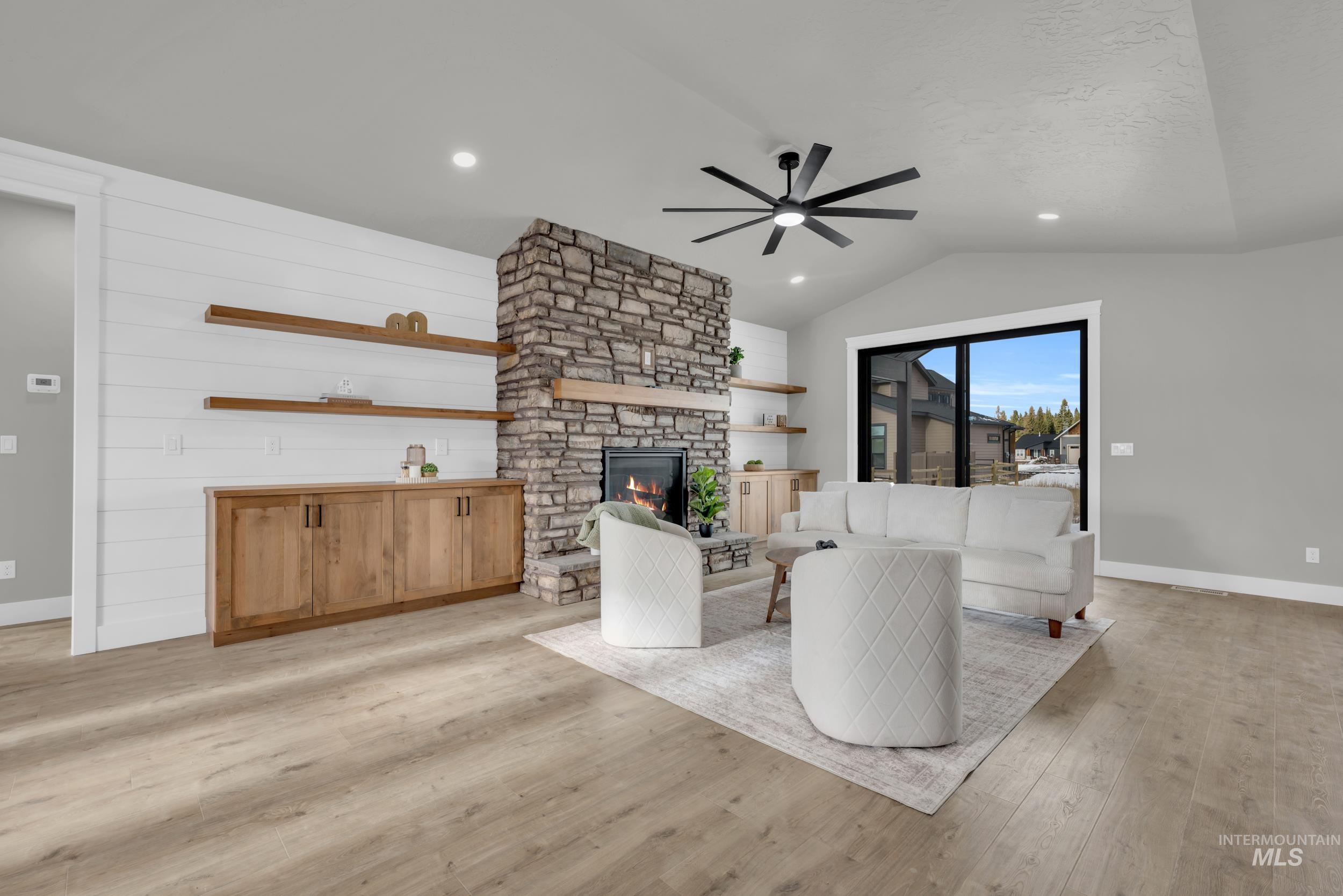 1107 Mo's Way McCall, ID 83638 - Photo 10 of 50 Living room with light wood finished floors, a fireplace, a ceiling fan, recessed lighting, and lofted ceiling