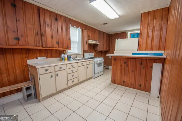 a kitchen with stainless steel appliances a sink window and cabinets