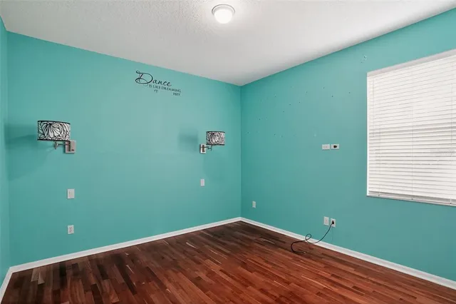 a view of an empty room with glass door and wooden floor