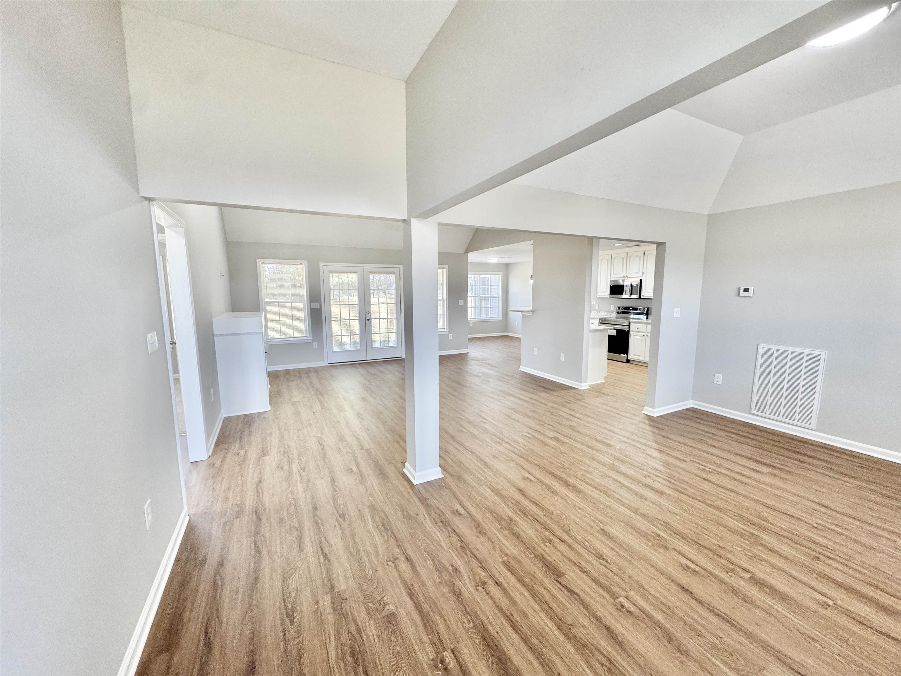 788 Bruce Road Whiteville, TN 38075 - Photo 12 of 39 Unfurnished living room featuring light wood-style floors and high vaulted ceiling