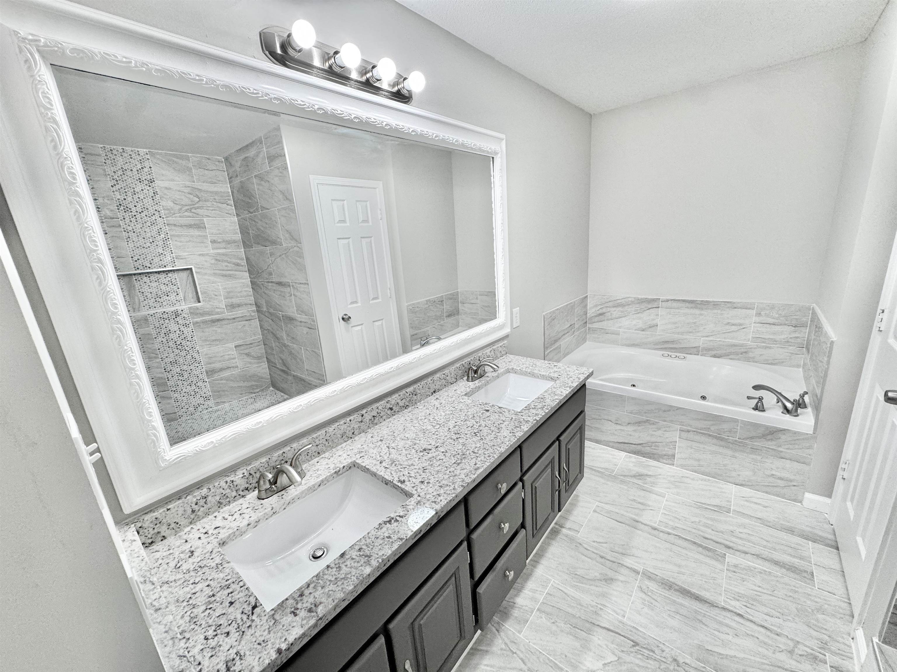 788 Bruce Road Whiteville, TN 38075 - Photo 17 of 39 Full bath featuring double vanity, a jetted tub, and light marble finish flooring