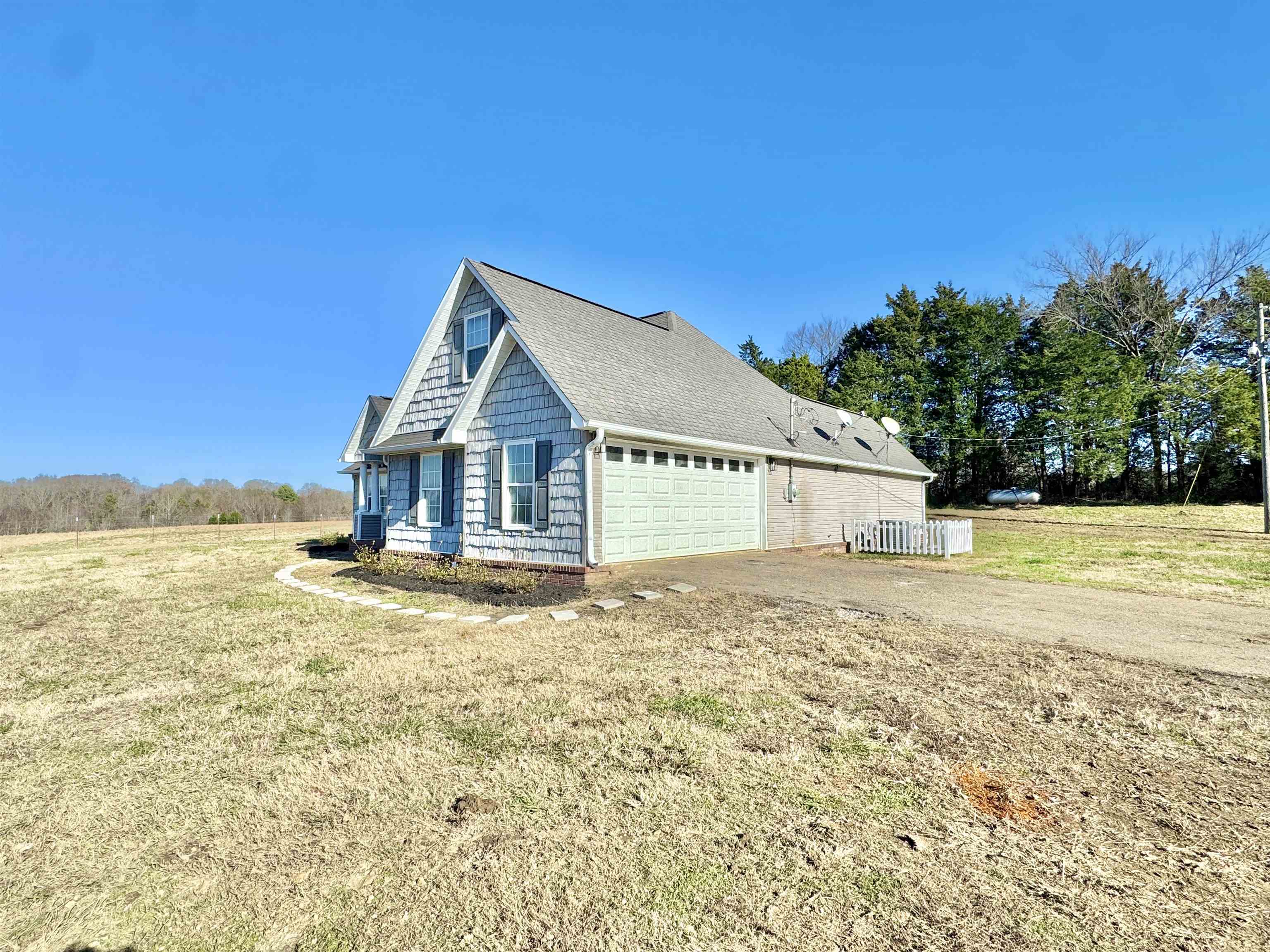 788 Bruce Road Whiteville, TN 38075 - Photo 27 of 39 View of home's exterior featuring a garage, a shingled roof, a lawn, and driveway